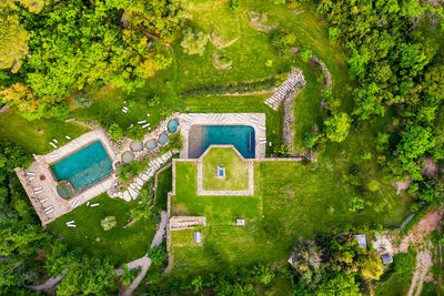 High angle view of house amidst trees and plants on field