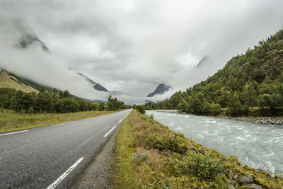 Road leading towards mountain against sky