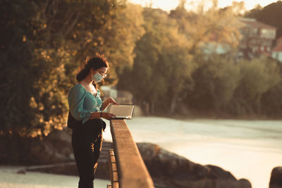 Woman using mobile phone while sitting on camera