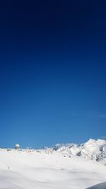 Scenic view of snowcapped mountains against clear blue sky