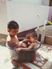 High angle view of boys sitting in tub outdoors