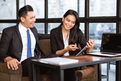 Businesswoman using mobile phone while sitting at office