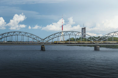 Bridge over river against cloudy sky