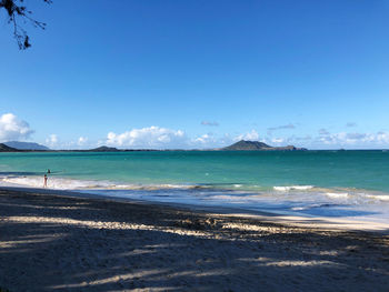 Scenic view of beach against blue sky