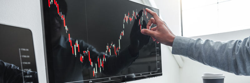 Cropped hand of man using digital tablet in office