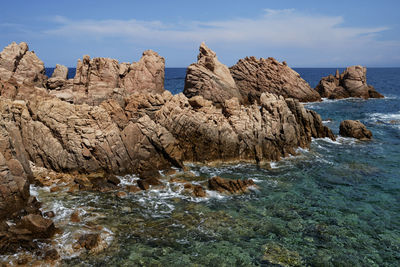 Rock formation on beach against sky