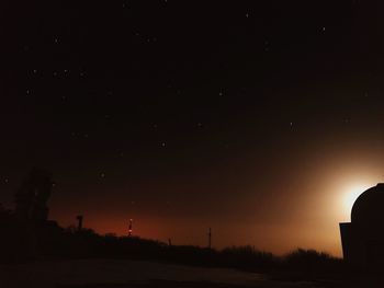 Silhouette landscape against sky at night