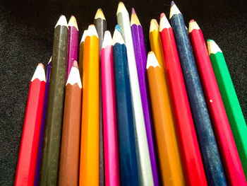 Close-up of colored pencils against black background