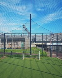 Man relaxing on soccer field against sky