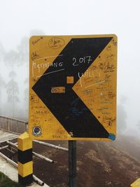 Close-up of road sign against sky