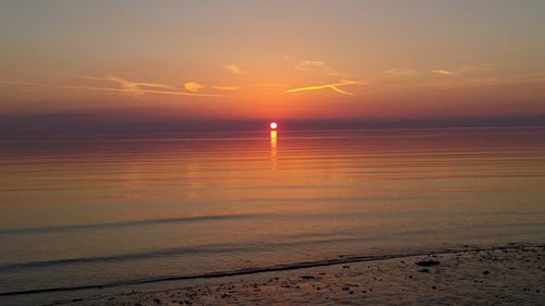 Scenic view of sea against romantic sky at sunset