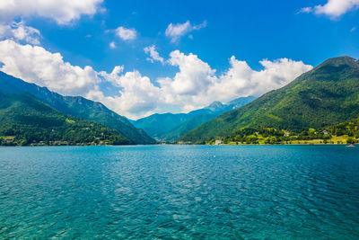 Scenic view of lake by mountains against sky