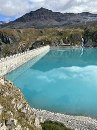 Scenic view of lake by mountains against sky