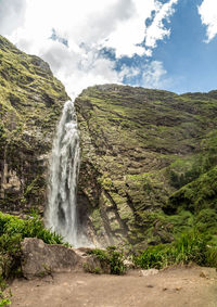 Scenic view of waterfall against sky