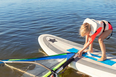 Rear view of woman in boat in lake