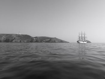 Sailboat sailing in sea against clear sky