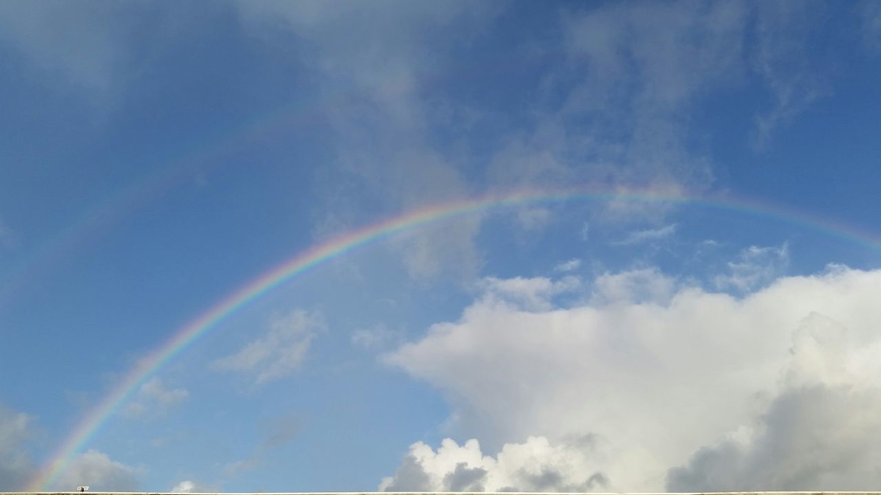 sky, cloud - sky, rainbow, beauty in nature, scenics, blue, low angle view, nature, tranquility, vapor trail, cloudy, tranquil scene, cloud, idyllic, outdoors, no people, day, multi colored, transportation, cloudscape