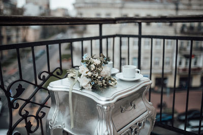 Close-up of flower vase on railing
