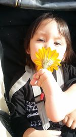 Close-up of woman holding yellow flowers