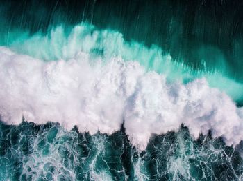 Panoramic view of sea waves splashing against blue sky