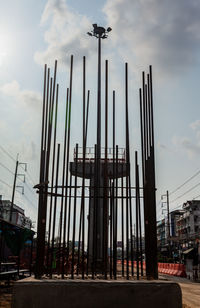 Low angle view of cranes against sky in city