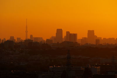 Silhouette buildings against clear sky during sunset