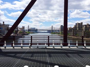 Bridge over river against cloudy sky