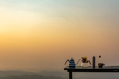 View of tea pot on table against sky during sunset