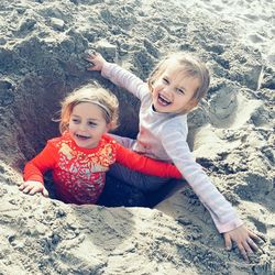 Portrait of happy mother and daughter on sand