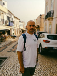 Portrait of bald mid adult man standing in city