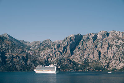 Scenic view of sea and mountains against clear sky