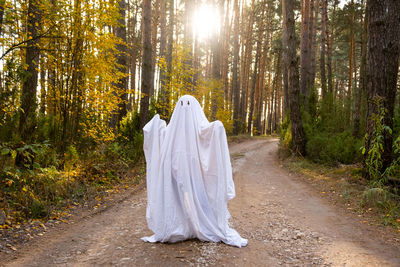 Rear view of woman standing in forest