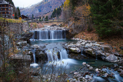 Scenic view of waterfall in forest against sky