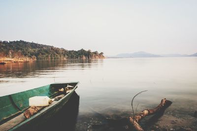 Boat moored in lake against sky