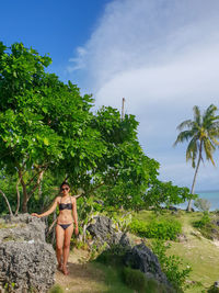 Full length of woman wearing bikini standing by trees