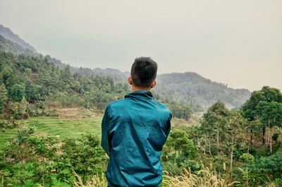 Rear view of woman standing on landscape