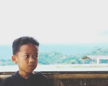 Portrait of boy looking at camera against sky