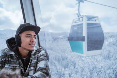 Portrait of young man standing against sky