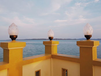 Built structure by sea against sky