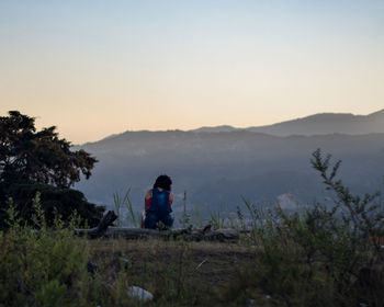Man looking at mountains against sky during sunset