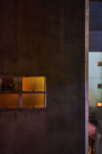 ILLUMINATED BUILDING SEEN THROUGH WINDOW