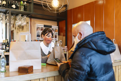 Mature customer in restaurant to pick up take out food during pandemic