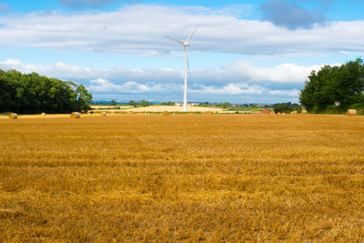 Scenic view of field against cloudy sky