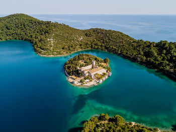 Aerial view of island monastery surrounded by vibrant blue water on mljet island in croatia.