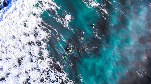 High angle view of surfers in the sea.
