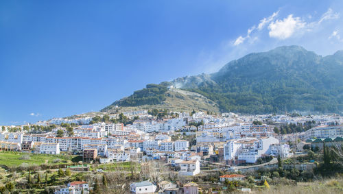 Buildings in town against blue sky