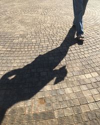 Low section of man walking on cobblestone street