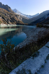 Scenic view of lake by mountains against sky