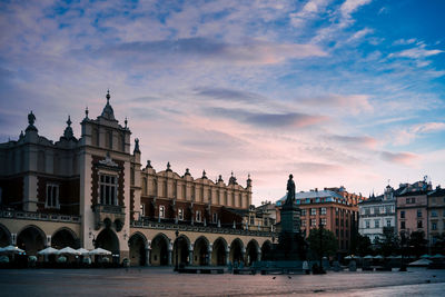 Buildings in city against cloudy sky