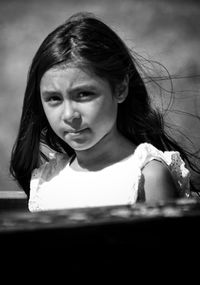 Close-up portrait of young woman against sky